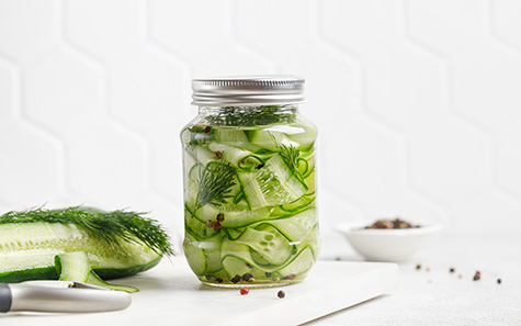 pickled cucumbers. slices of marinated cucumbers in glass jars.
